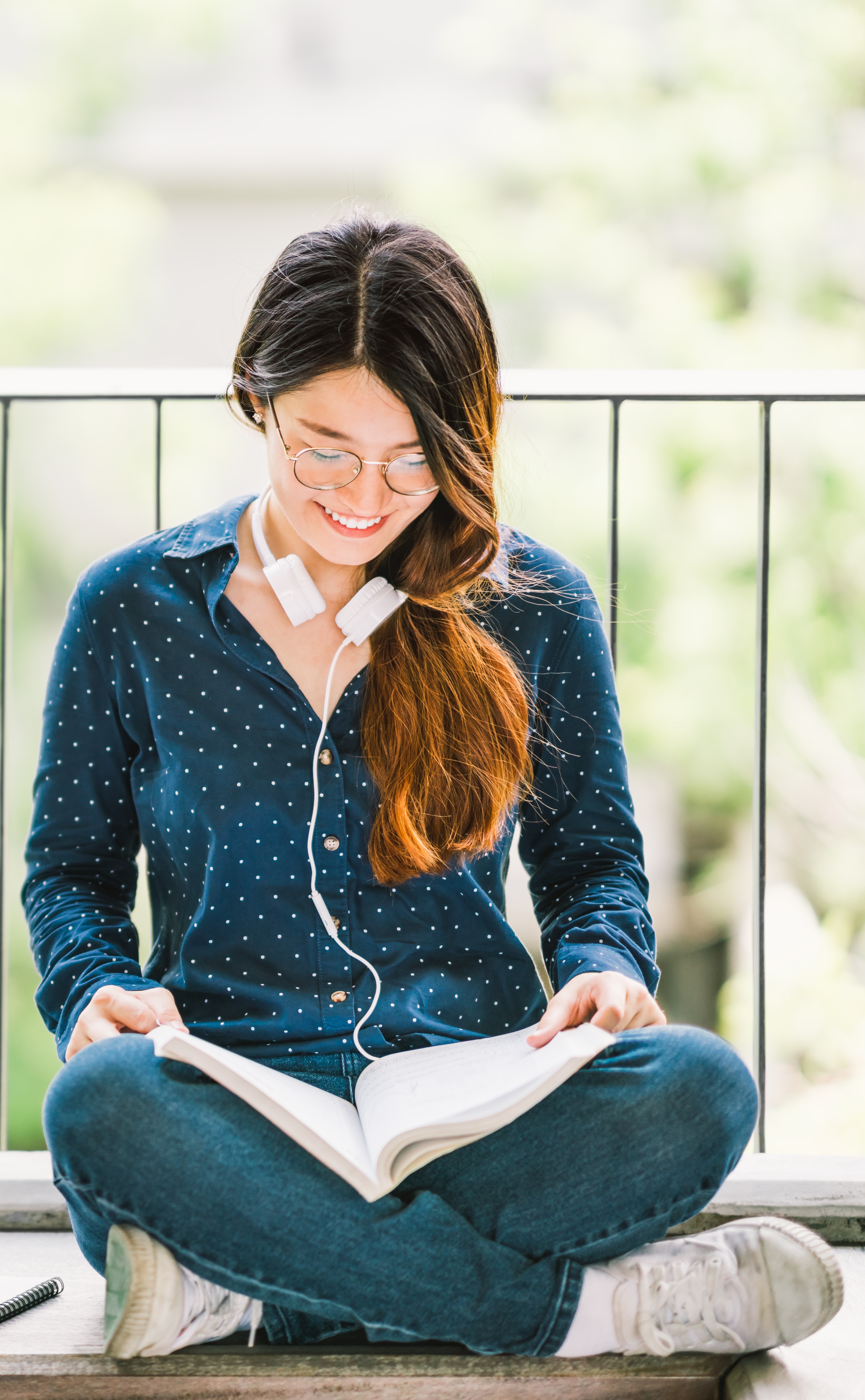 Female student reading a book on campus