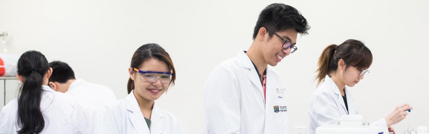 Students wearing lab coats working