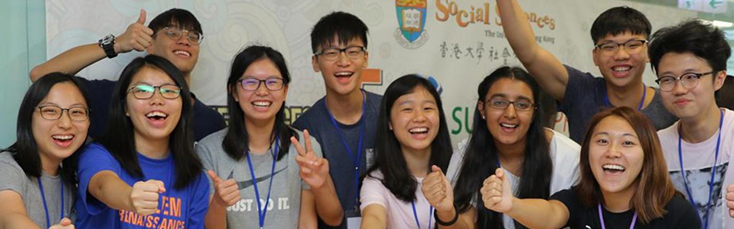 Students cheering in front of a social sciences banner