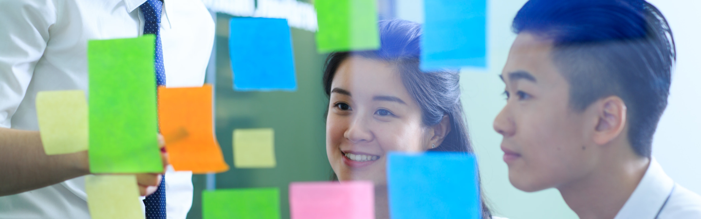 Students putting memo pad on the glass wall