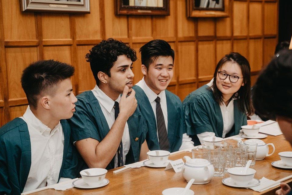 Students wearing green gown at a High Table DInner