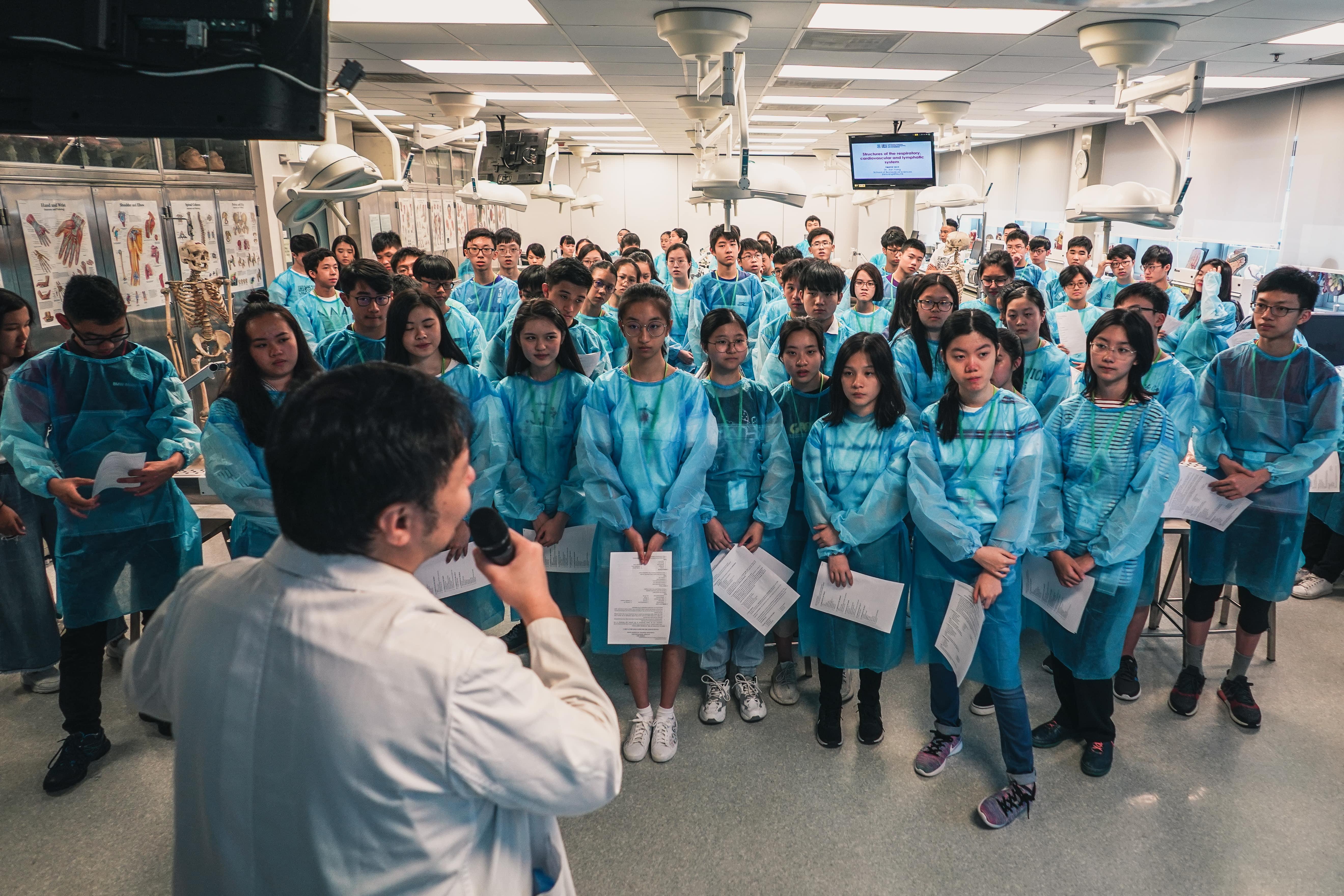 Secondary school students wearing protective clothing in the laboratory