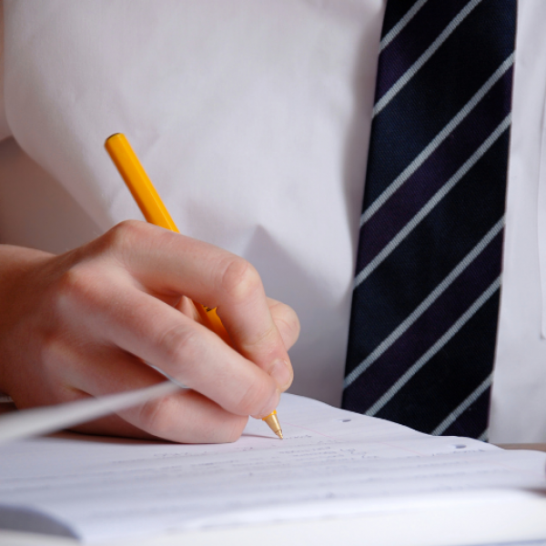 Students is writing on a notebook