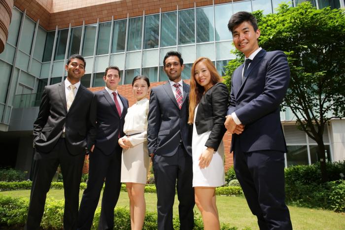 Students posing in front of Chi Wah while wearing formal attire