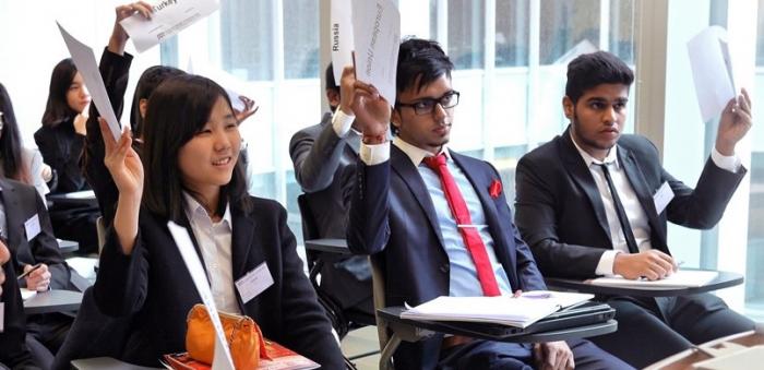 Students wearing business attire raising hand