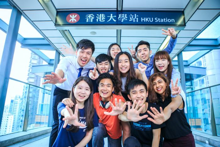 一群學生在香港大學的地鐵標誌下合照