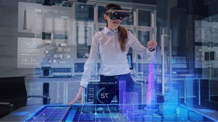 Professional Female Architect wearing Augmented Reality Headset makes gestures and redesigns 3D City Model. High Tech Office use Virtual Reality Holographic Modeling Software Application.