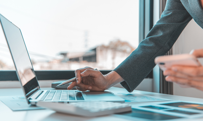 Finance workers are reviewing the company's financial data on a laptop