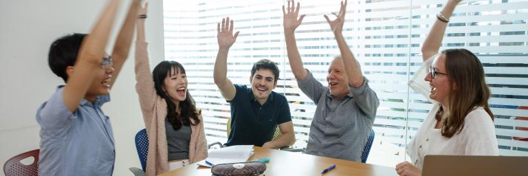 People high fiving in a meeting room