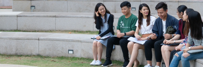 Six asian students are sitting on the courtyard of Centennial Garden