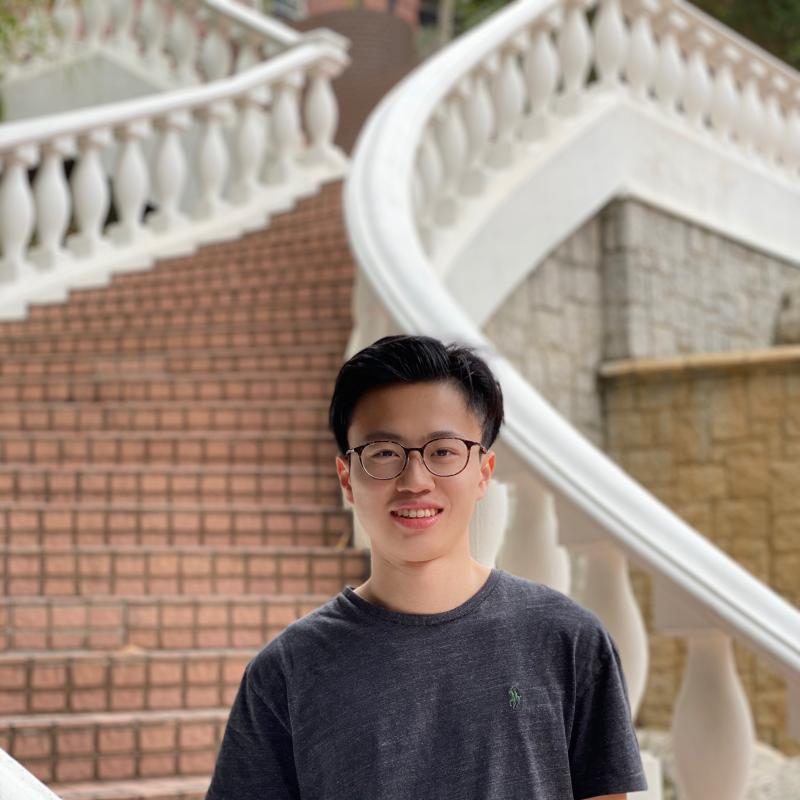 A boy standing in front of stairs