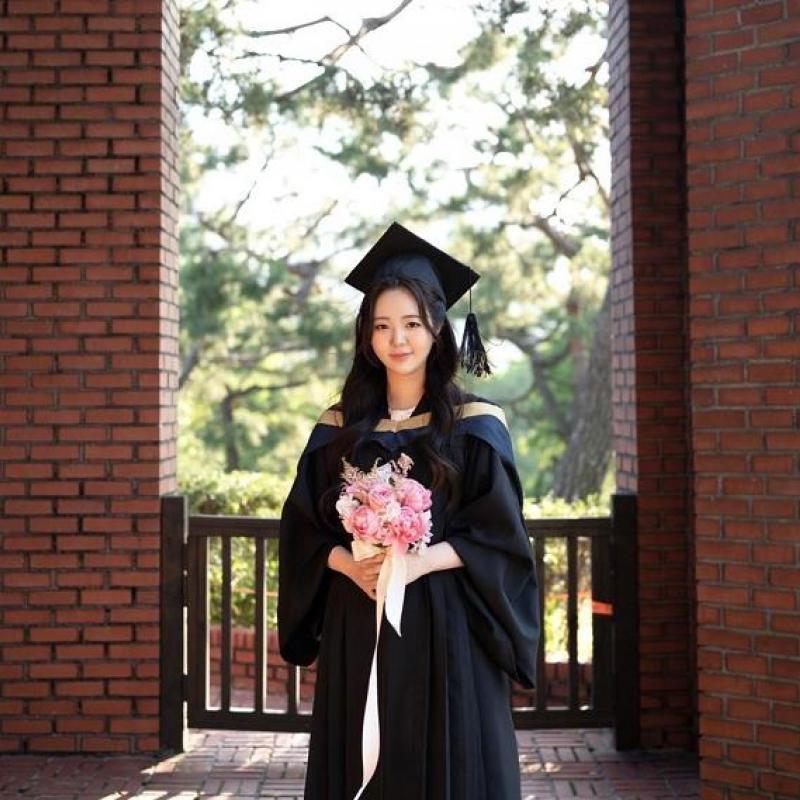 A girl standing in a garden holding flower